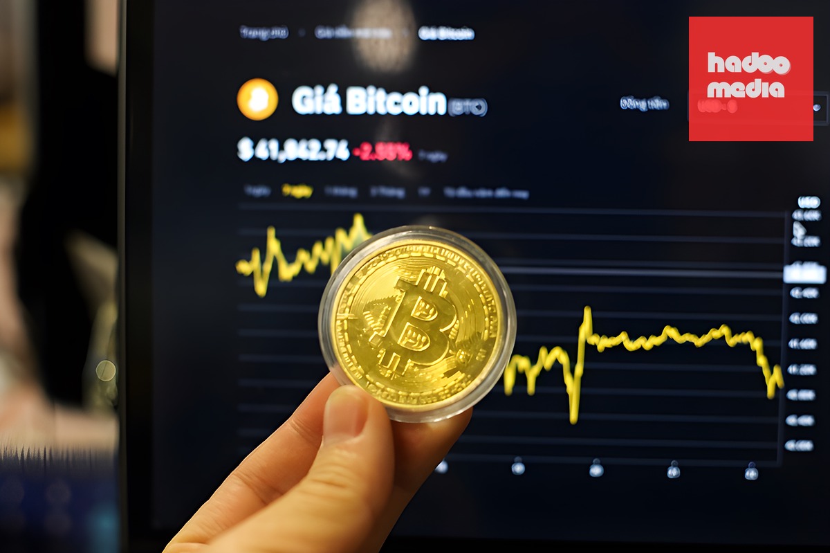 Đồng xu biểu tượng Bitcoin trước biểu đồ diễn biến giá. Ảnh: Khương Nha