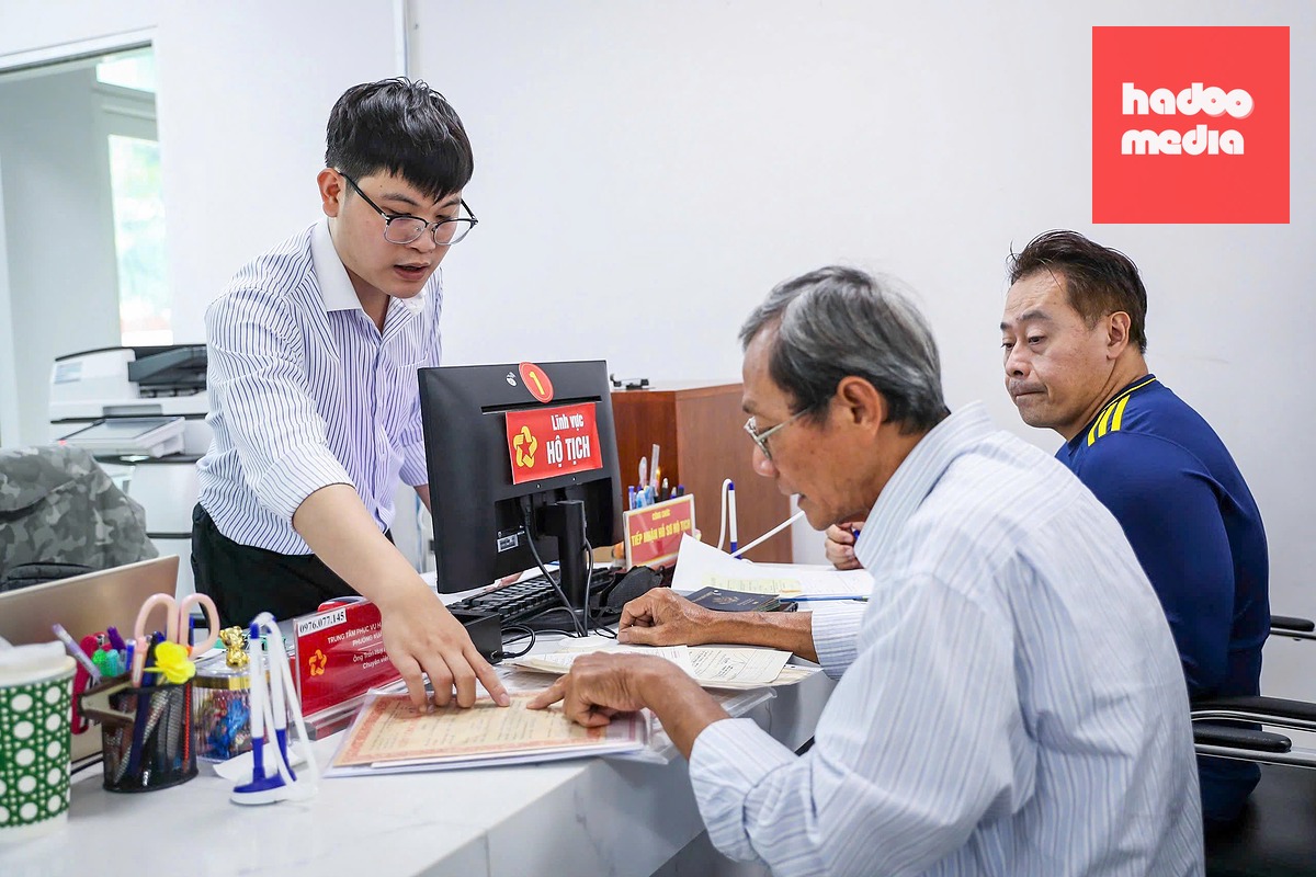 Công chức phường Xuân Hòa (TP.HCM) hướng dẫn người dân làm thủ tục hộ tịch - Ảnh: QUANG ĐỊNH