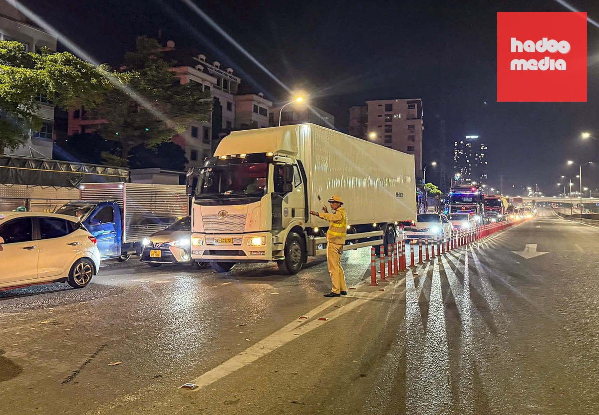 Khoảng 23h, dòng xe lưu thông trên cầu vượ Mai Dịch được hướng dẫn đi xuống vành đai 3 dưới thấp - Ảnh: THIÊN KHÔI