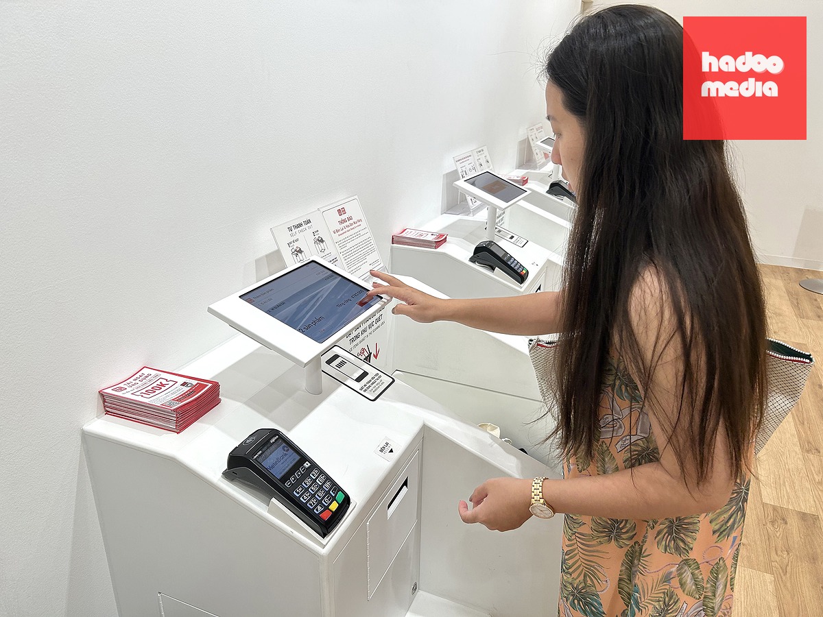 Khách hàng đặt sản phẩm đã mua vào khu vực máy quét và tự thanh toán chạm thẻ tín dụng hoặc quét QR khi mua hàng tại cửa hàng UNIQLO ở phường Thảo Điền (TP.HCM) - Ảnh: T.T.D.