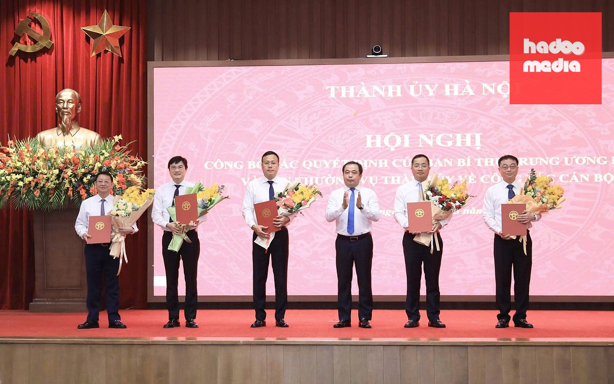 Bí thư Thành ủy Hà Nội tặng hoa các cán bộ được trao quyết định trong sáng 25-5 - Ảnh: N.T.