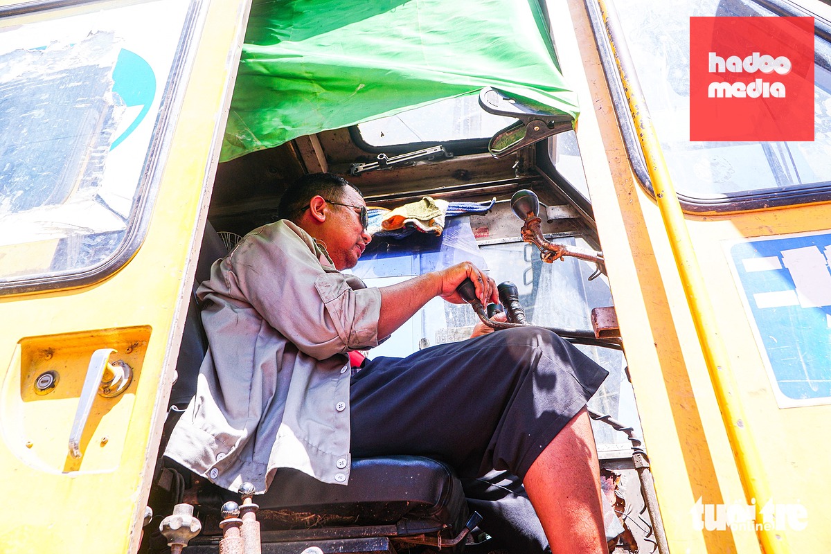 Trời nắng gắt, trong cabin không có điều hòa, các công nhân than: "Nóng quá" - Ảnh: PHẠM TUẤN