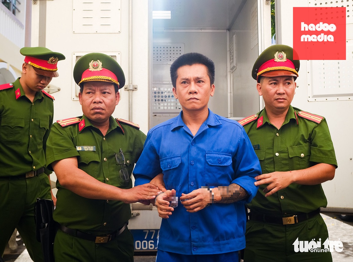 Bị can Phạm Anh Tài - còn gọi Tài "đen" - được dẫn giải từ xe thùng lên phòng xét xử - Ảnh: TẤN LỰC