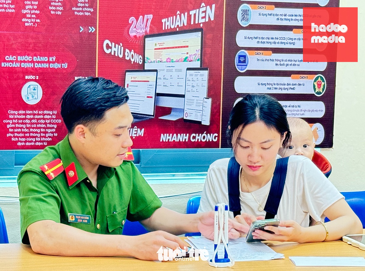 Cán bộ công an hướng dẫn người dân thực hiện các dịch vụ trên VNeID - Ảnh: DANH TRỌNG