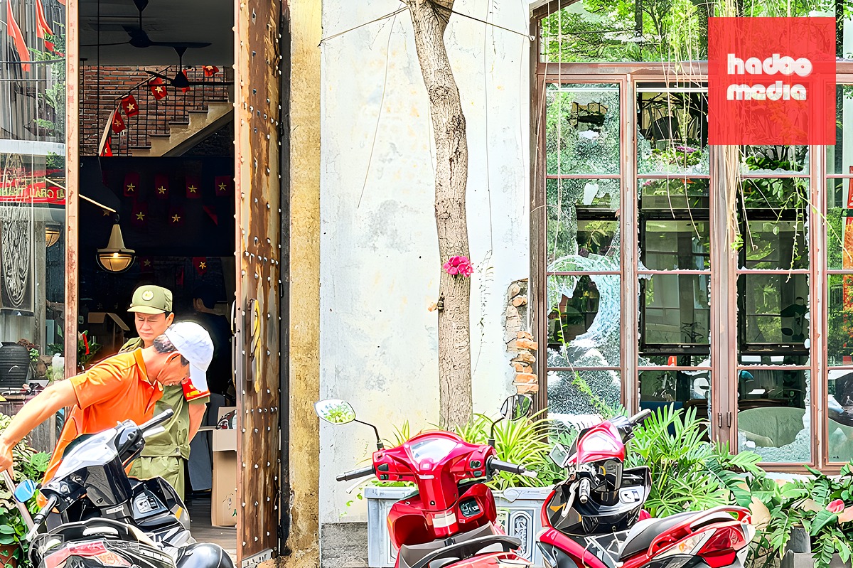 Kính của quán cà phê bị người đàn ông nước ngoài đập vỡ, đến trưa 30/5 nhân viên quán vẫn đang quét dọn. Ảnh: Ngọc Trường