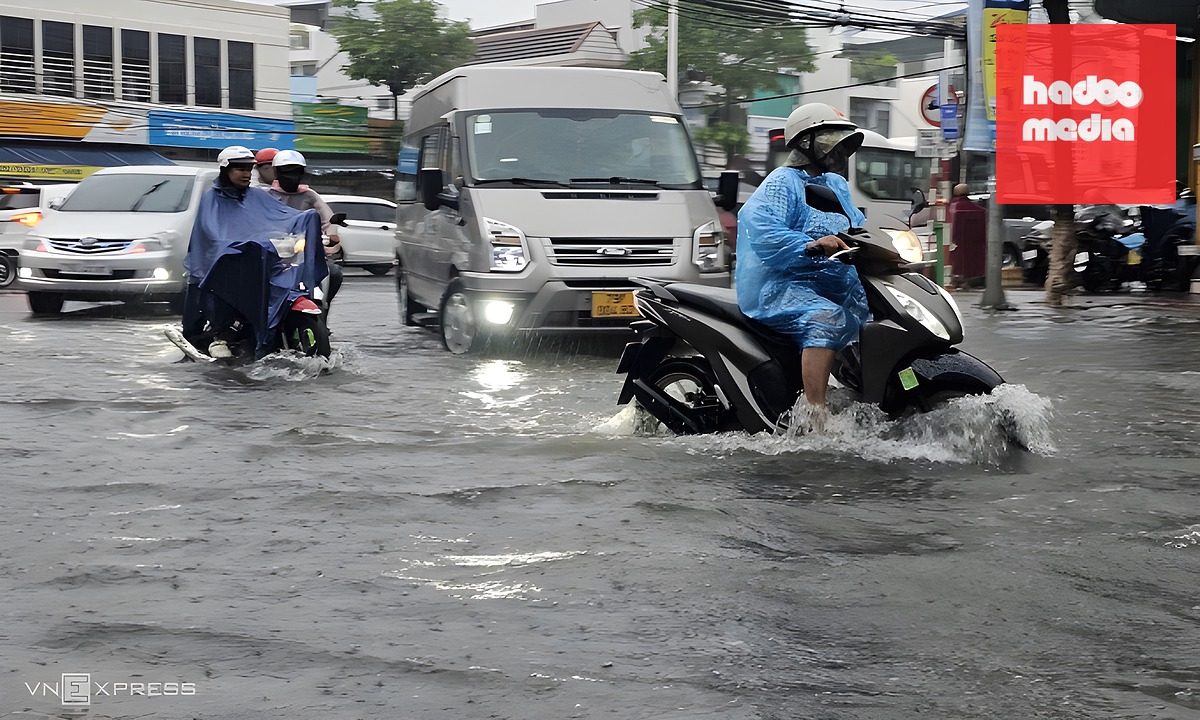Người dân chạy xe qua nước ngập ở đường Mai Xuân Thưởng. Ảnh: Bùi Toàn