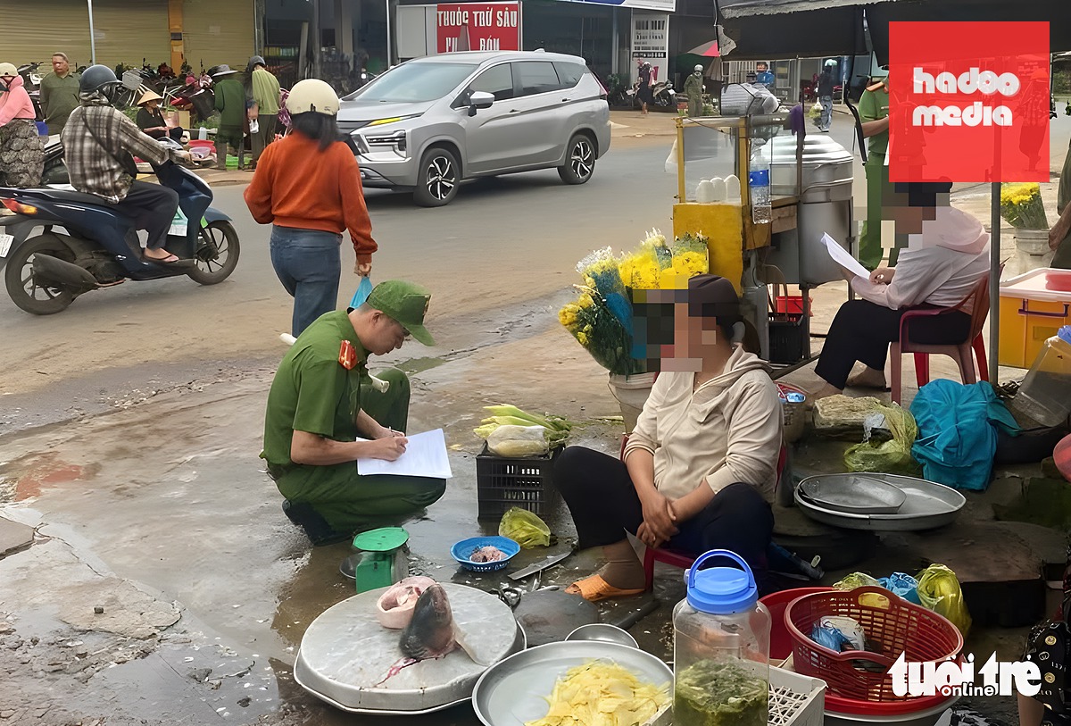 Ngành công an ra quân tuyên truyền, yêu cầu tiểu thương ký cam kết không lấn chiếm lòng lề đường tại một chợ chồm hổm trên quốc lộ 27 - Ảnh: TRUNG TÂN