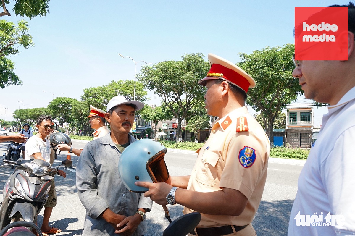 Lực lượng cảnh sát giao thông dừng xe, tặng mũ bảo hiểm xịn cho người dân - Ảnh: ĐOÀN CƯỜNG