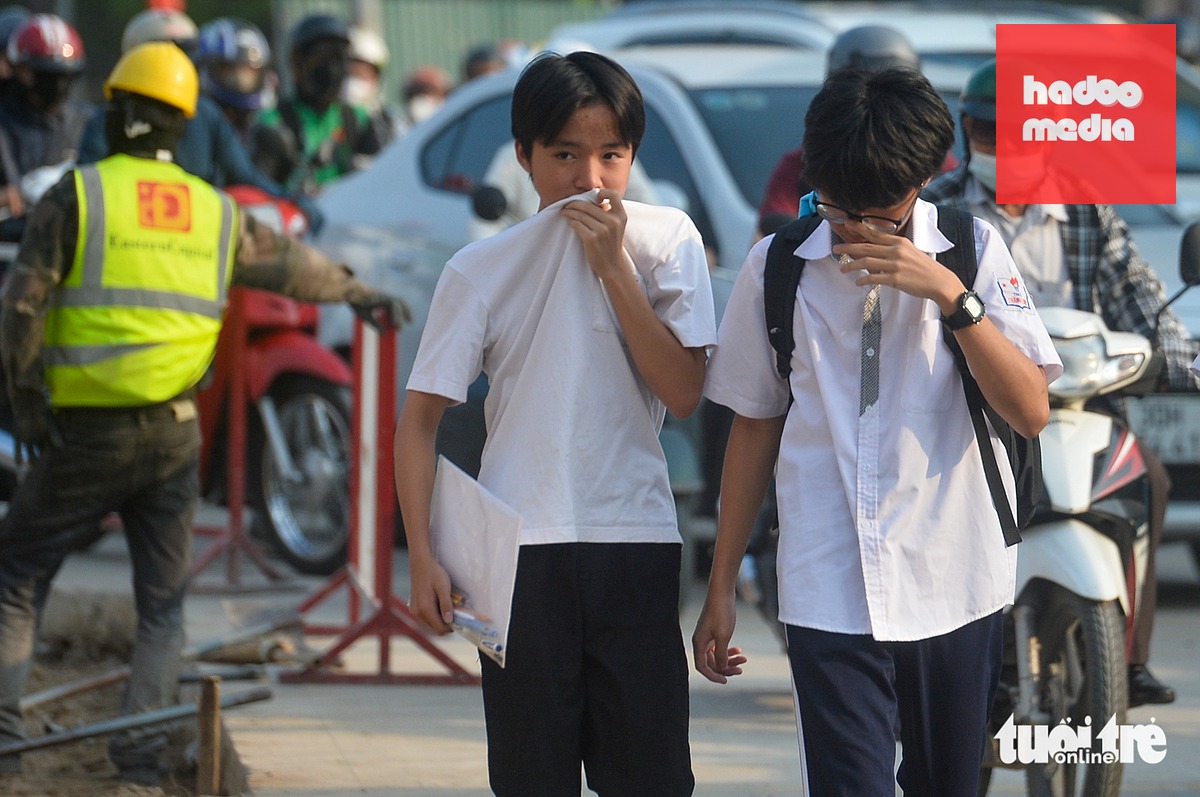Người đi bộ khi di chuyển qua khu vực nút giao La Thành - Nguyễn Chí Thanh (Hà Nội) phải bịt mũi vì bụi - Ảnh: PHÚC TÀI
