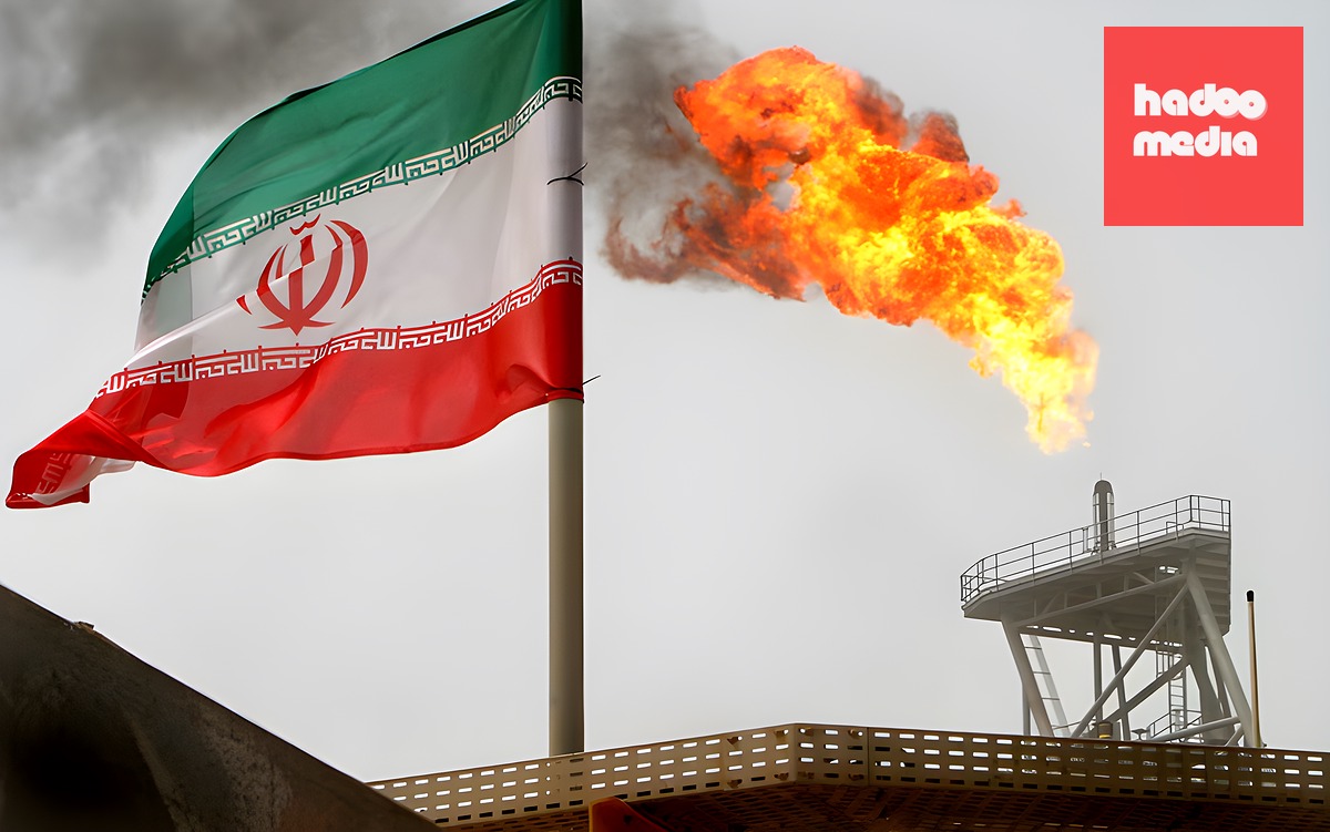 Một giàn khai thác dầu cùng một lá cờ Iran - Ảnh: REUTERS