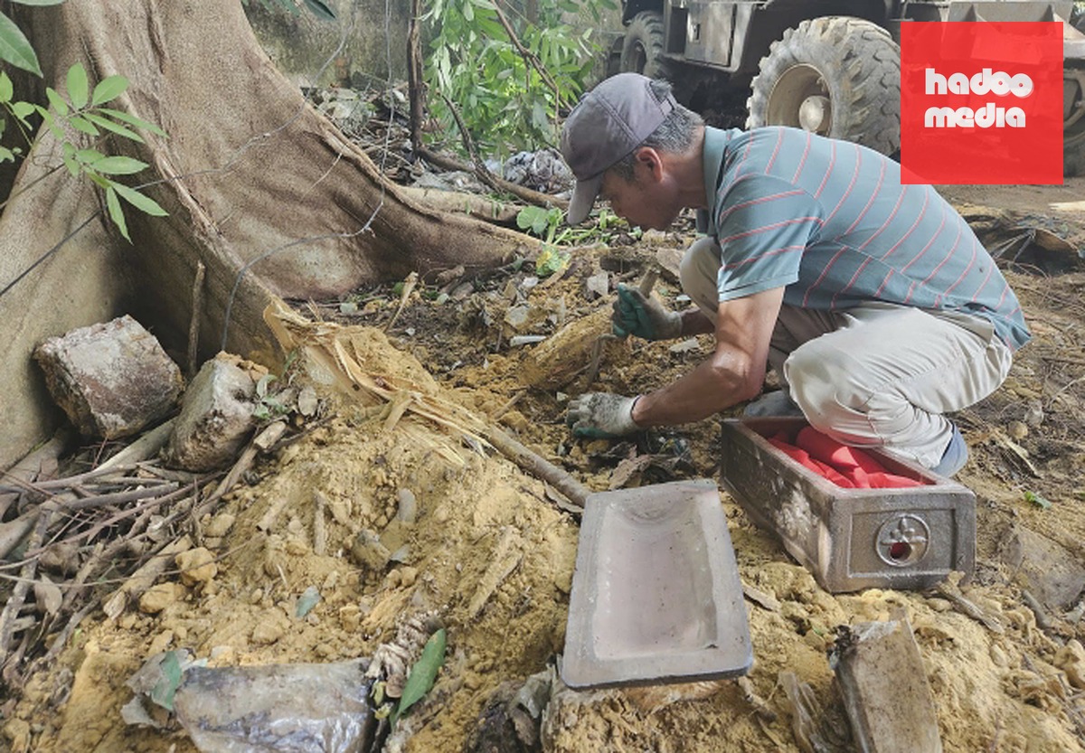 Công nhân tỉ mỉ tìm kiếm hài cốt bên một gốc cây khi thi công mở rộng đường Tây Thành. Ảnh: Hoa Lư