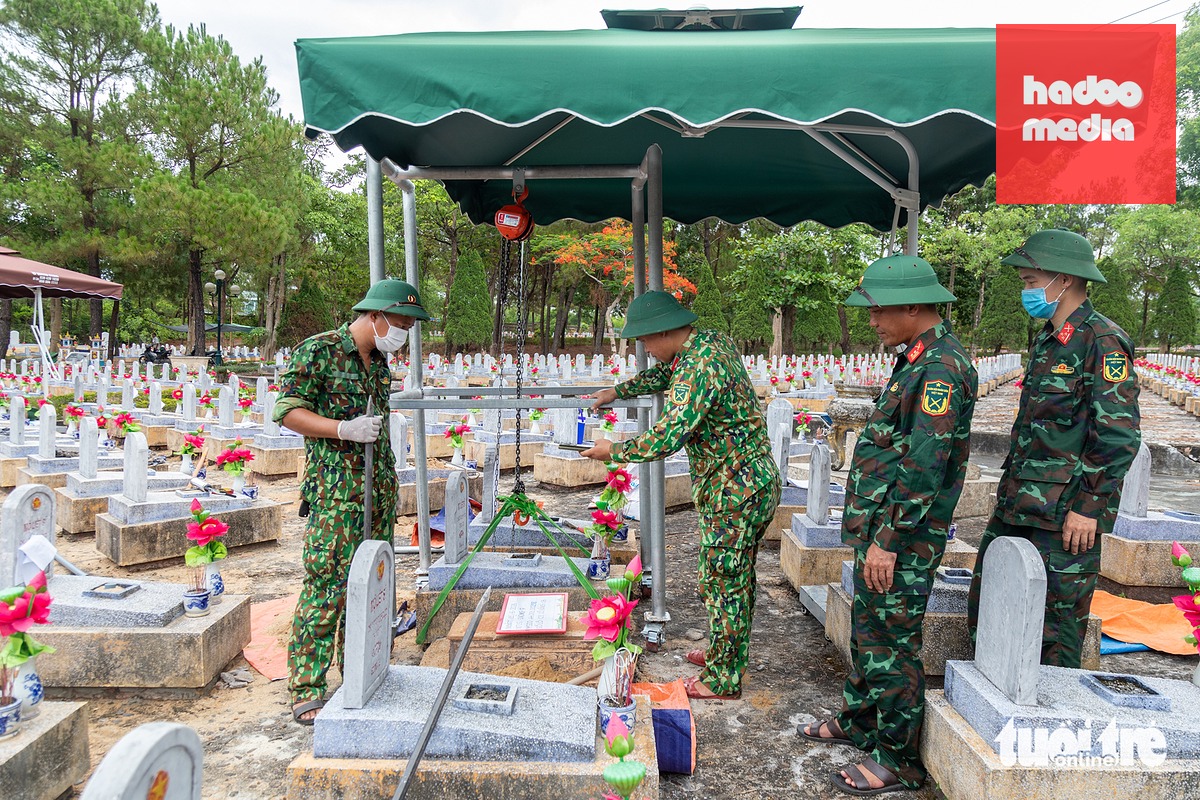 Cán bộ Đội 584 lấy mẫu sinh phẩm tại Nghĩa trang liệt sĩ quốc gia Đường 9 - Ảnh: HOÀNG TÁO