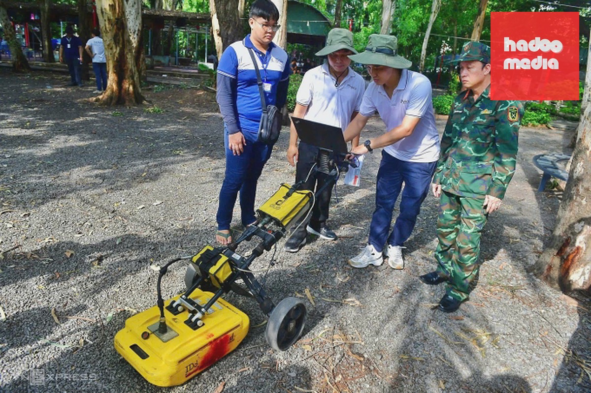 Đại tá Nguyễn Đình Chuẩn, Phó chính ủy Bộ Tư lệnh TP HCM cùng các chuyên gia dùng thiết bị quét radar lòng đất ở khu vực nghi có hố chôn tập thể liệt sĩ trong công viên Lê Thị Riêng. Ảnh: Thanh Tùng