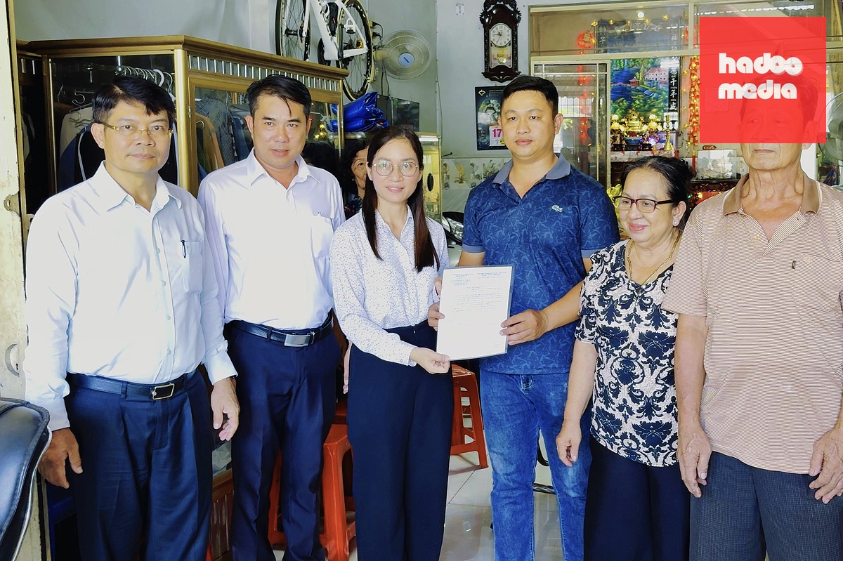 Bà Nguyễn Kim Mai - Phó chủ tịch UBND xã Bình Chánh - trao thông báo sửa chữa nhà đến gia đình anh Nguyễn Tấn Phát - hộ dân ảnh hưởng bởi dự án nâng cấp, mở rộng quốc lộ 1. Anh Phát cho biết chỉ sau 5 ngày làm việc, gia đình anh đã nhận được thông báo sửa chữa nhà - Ảnh: HOÀNG HƯNG