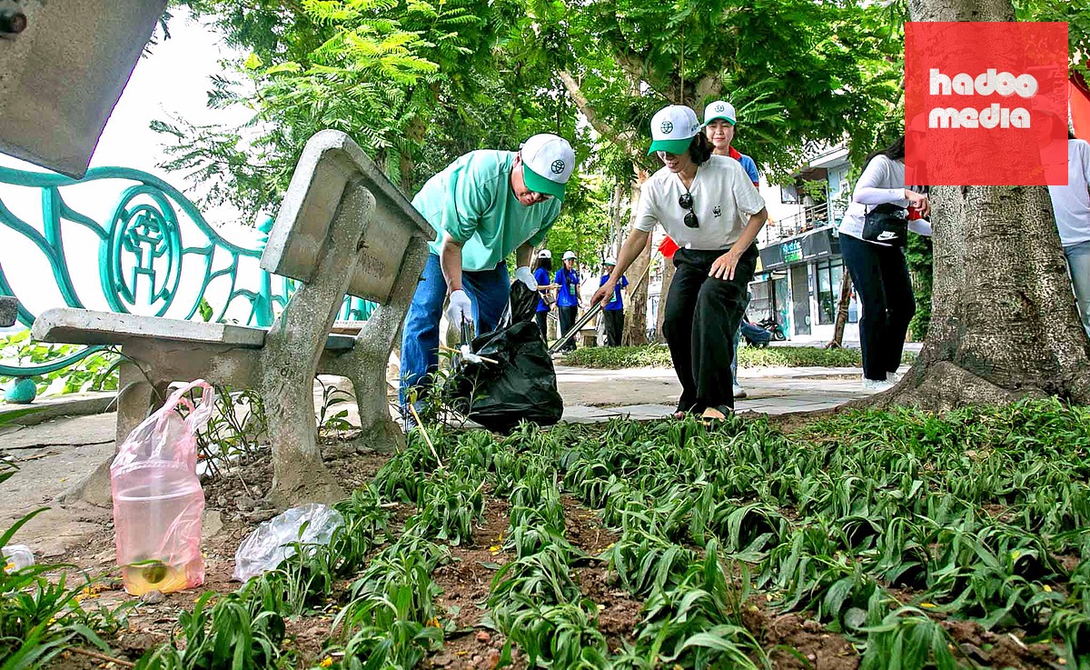 Ông Kim Beomchang, Giám đốc đổi mới nhân sự Lotte Hàn Quốc (áo xanh) và bà Park Minhye, Tổng giám đốc WWF Hàn Quốc (áo trắng) cùng nhiều đại biểu, tình nguyện viên tham gia hoạt động thu gom rác tại khu vực hồ Tây - Ảnh: C.TUỆ