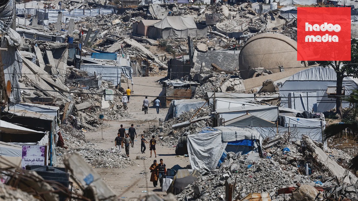 Palestinci procházejí kolem trosek obytných budov v uprchlickém táboře Džabálija na severu Pásma Gazy (12. června 2026)