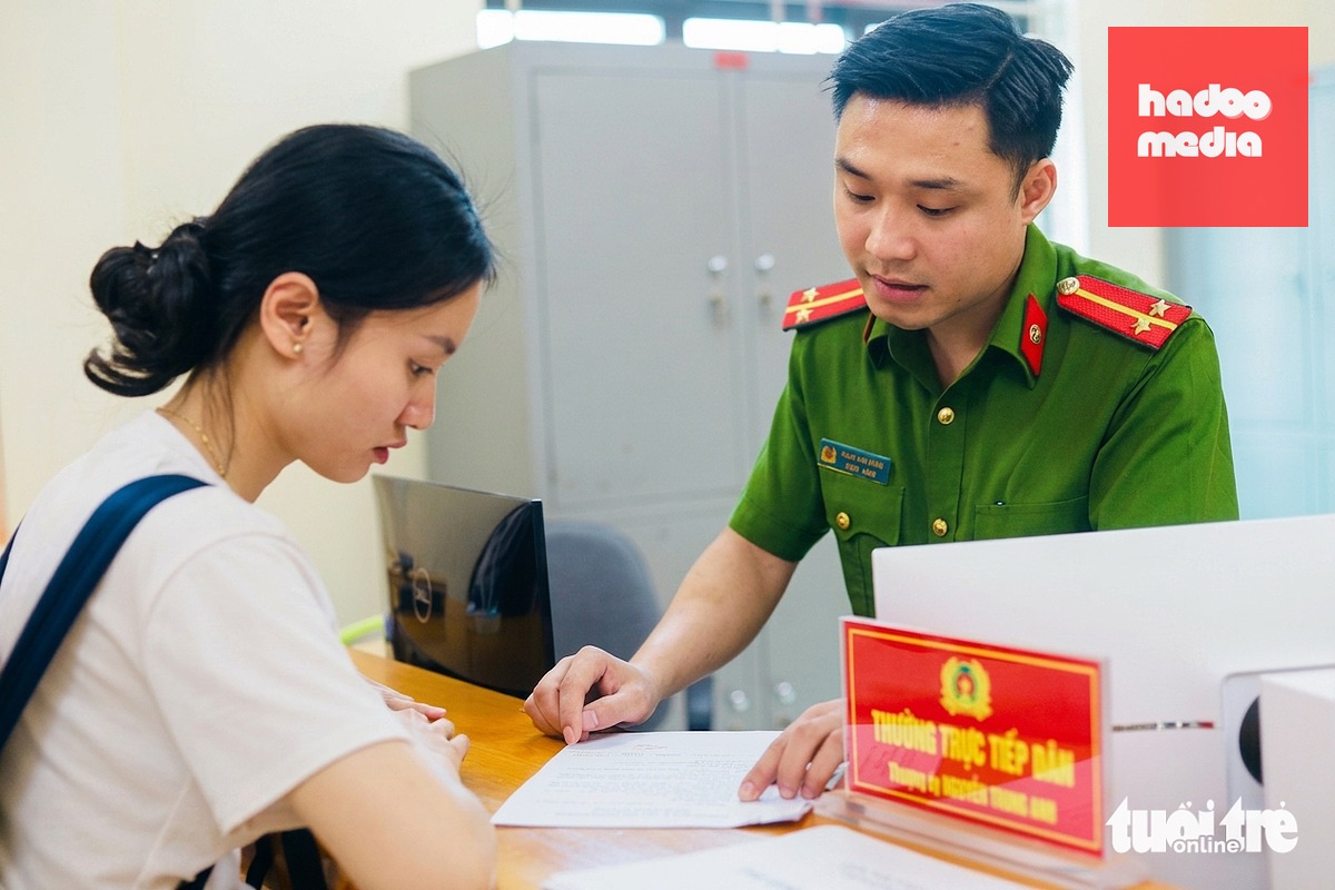 Cán bộ công an xã hướng dẫn người dân thực hiện thủ tục hành chính - Ảnh: DANH TRỌNG