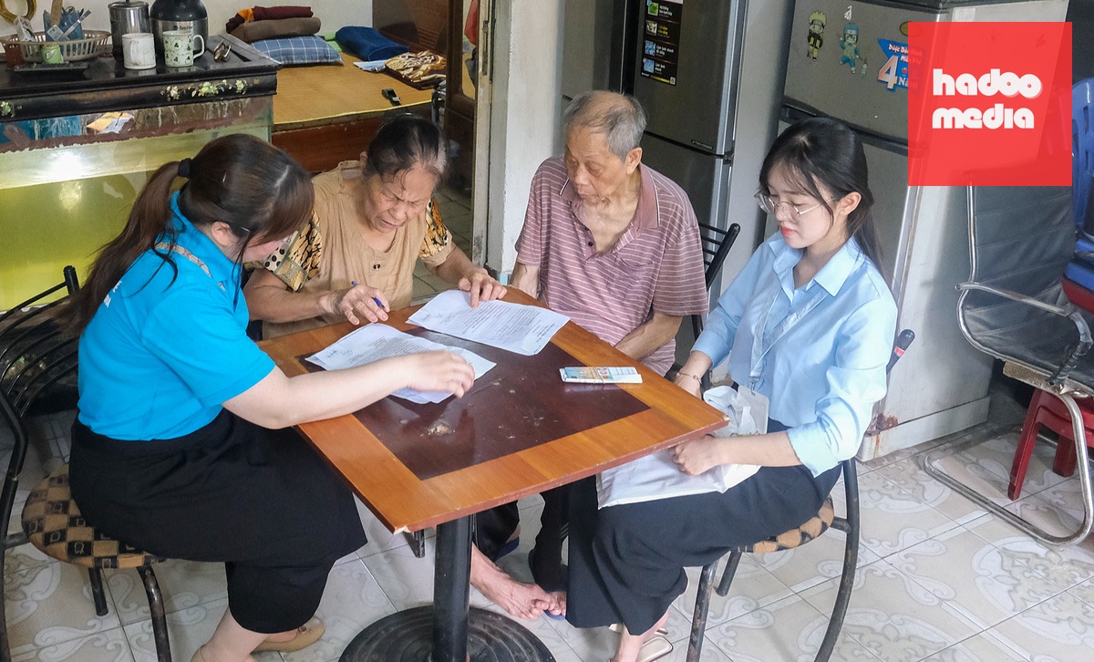 Một tổ xung kích hỗ trợ người cao tuổi không thể đi lại làm thủ tục ủy quyền lương hưu ở nhà tại phường Kim Liên (Hà Nội) - Ảnh: HÀ QUÂN