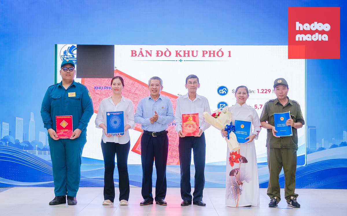 Ông Võ Văn Đức, Bí thư Đảng ủy, Chủ tịch HĐND phường Nhiêu Lộc (thứ 3 từ trái sang), trao quyết định cho các cán bộ làm việc tại các khu phố mới sau sắp xếp