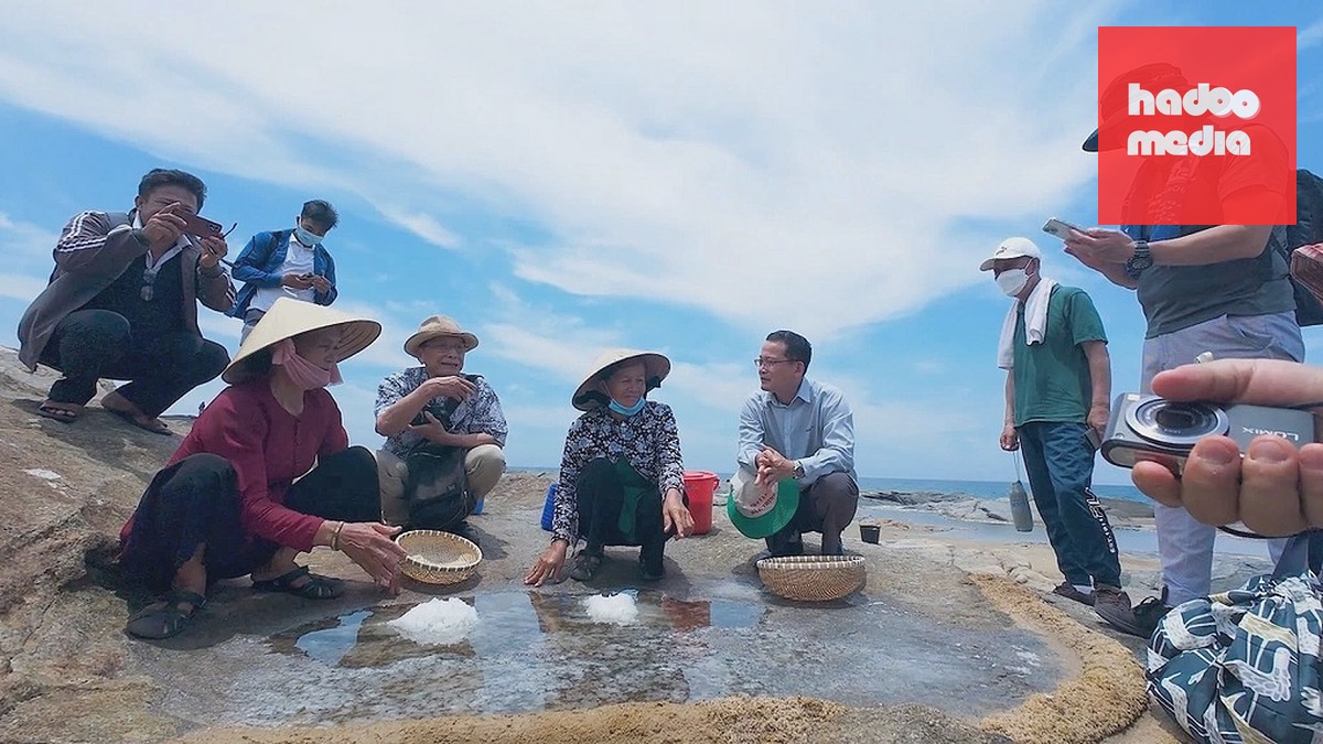 Nhà báo Suzuki Katsuhiko (ngồi, thứ 5 tính từ phải sang) tham quan trảng muối trên đá ở làng Gò Cỏ. Ảnh: Vũ Linh