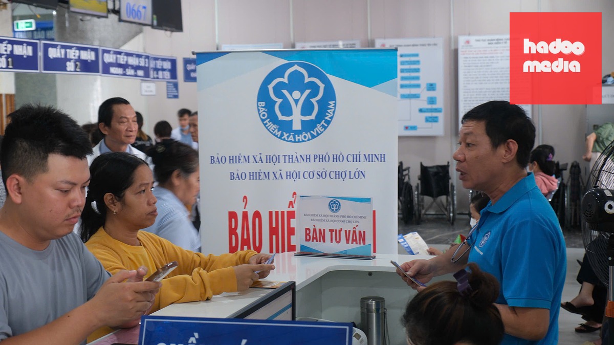 Chị Trương Nhật Minh (áo vàng) - người dân TP.HCM được cán bộ Bảo hiểm xã hội Chợ Lớn tư vấn thêm về nhiều chính sách mới của BHYT khi đến gia hạn thẻ BHYT tại Bệnh viện An Bình - Ảnh: NGÂN HÀ