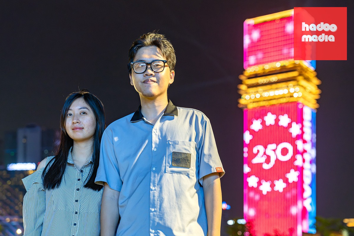 Hai bạn Hiền (phải) và Trúc (ngụ phường Bình Tân) chụp ảnh lưu niệm cạnh tòa nhà Saigon Marina IFC cùng hình ảnh biểu trưng mừng 250 năm Quốc khánh nước Mỹ - Ảnh: VĂN TRUNG