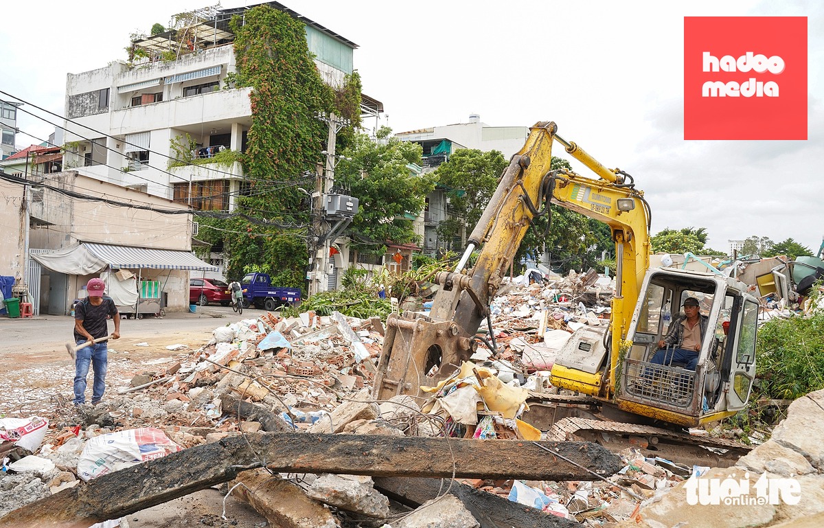 Nhiều nhà dân dọc tuyến hẻm đường Bùi Đình Túy (rạch Long Vân Tự, phường Bình Thạnh) vẫn tích cực thu dọn phế liệu xây dựng để làm sạch mặt bằng - Ảnh: THUẬN VĂN