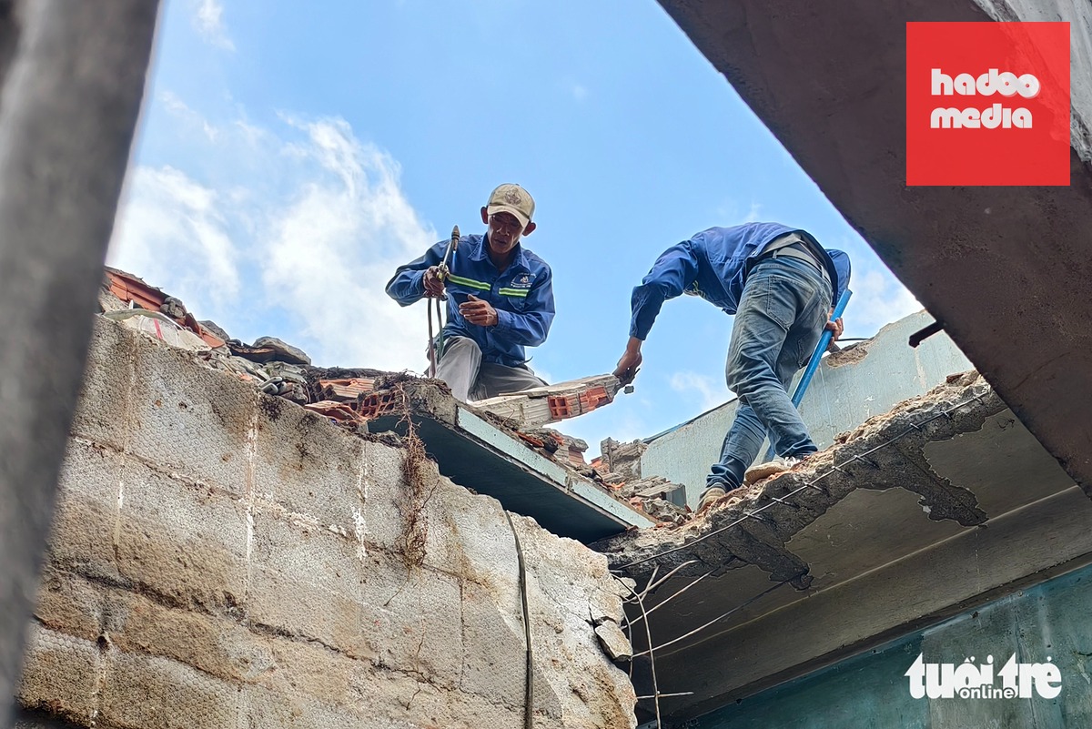 Công nhân tháo dỡ một căn nhà để bàn giao mặt bằng cho dự án nâng cấp, mở rộng quốc lộ 1 - Ảnh: NGỌC KHẢI