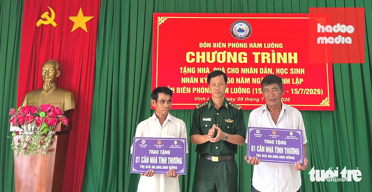 Đại diện lãnh đạo Ban Chỉ huy Bộ đội biên phòng tỉnh Vĩnh Long trao bảng tượng trưng hỗ trợ xây dựng nhà tình thương cho 2 hộ dân có hoàn cảnh khó khăn - Ảnh: H.T.