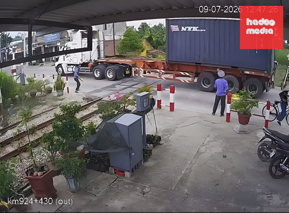 Chiếc container vẫn lao qua đường sắt dù còi, đèn tín hiệu đã bật, gác chắn đang hạ - Ảnh: Cắt từ video