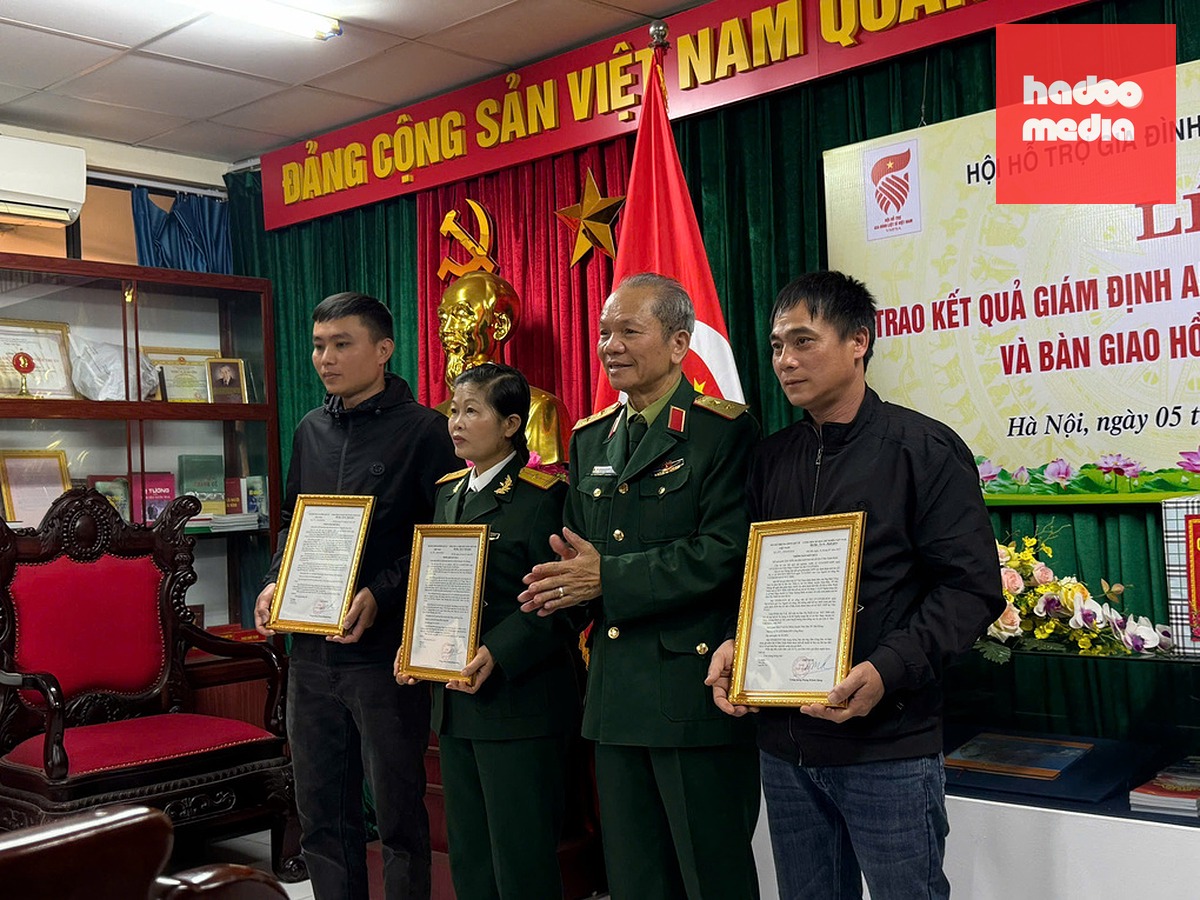 Ông Đào Công Sức (bìa phải) tiếp nhận kết quả giám định ADN của liệt sĩ Huân. Ảnh: Gia đình cung cấp