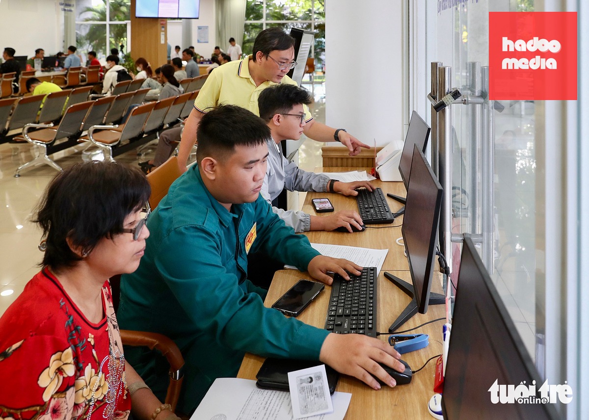 Lực lượng dân quân thường trực hướng dẫn người dân sử dụng máy tính ở Trung tâm Phục vụ hành chính công phường Bình Tiên để nộp hồ sơ trực tuyến