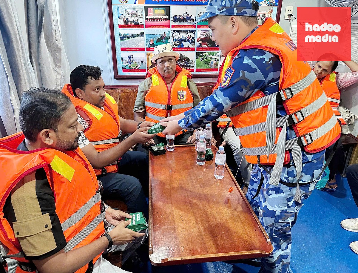 Cảnh sát biển cứu hộ các nạn nhân đưa lên tàu và hỗ trợ họ ăn uống - Ảnh: NGHỊ VINH