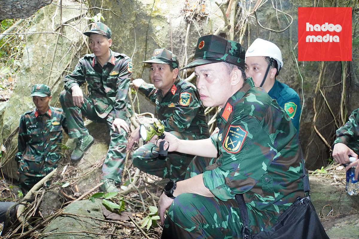 Đại tá Trần Hữu Ích (người cầm đèn pin) cùng bộ đội tìm kiếm hài cốt liệt sĩ ở hang Đá Sập - Ảnh: KHẢI ĐĂNG