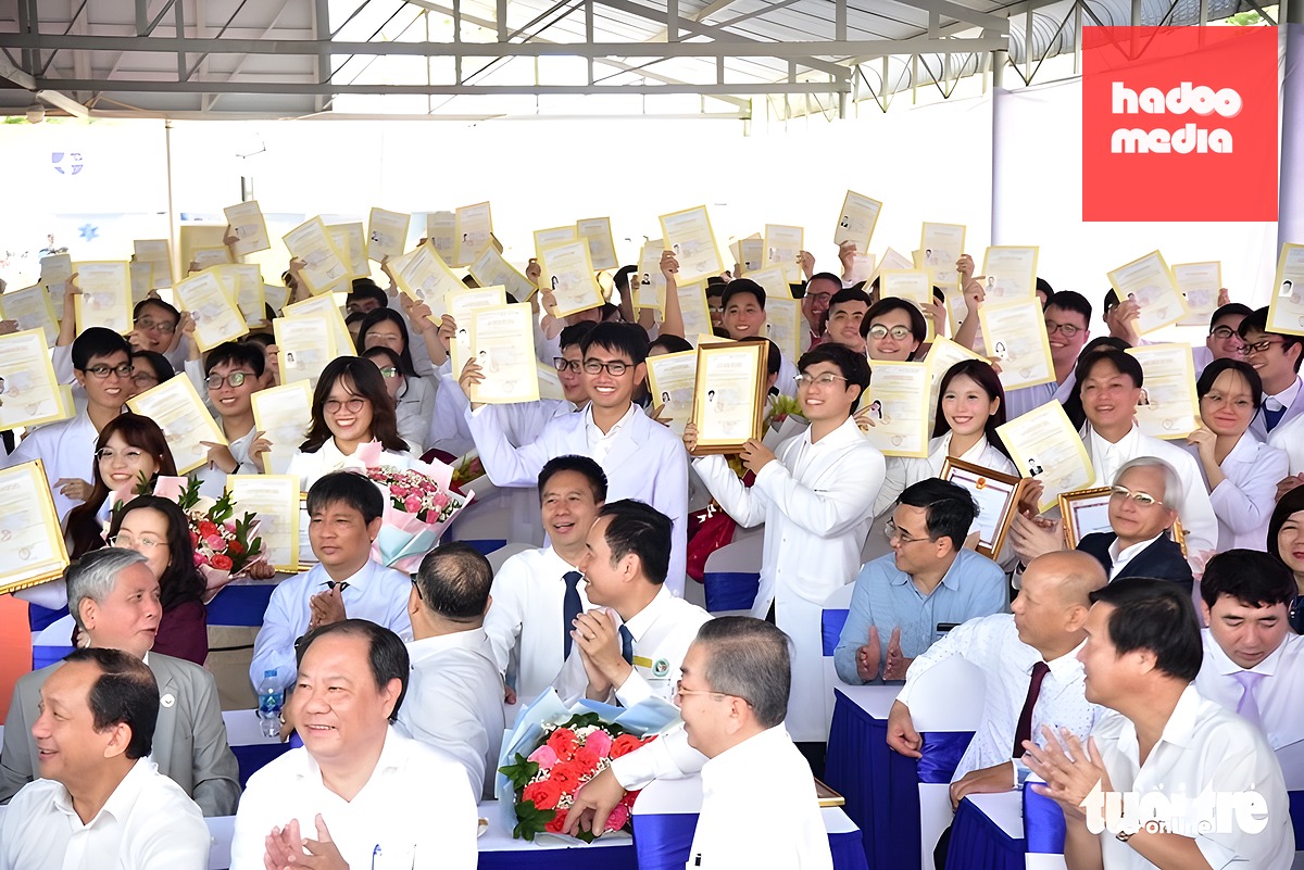 Các bác sĩ trẻ tự hào giơ cao giấy chứng nhận hoàn thành chương trình thí điểm thực hành - Ảnh: TRÍ ĐỨC