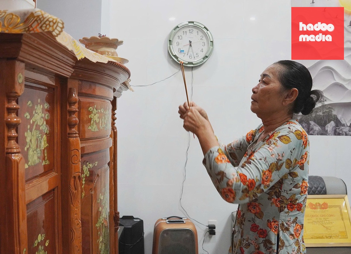 Bà Lê Thị Mừng thắp hương cho mẹ và anh trai. Ảnh: Nam An