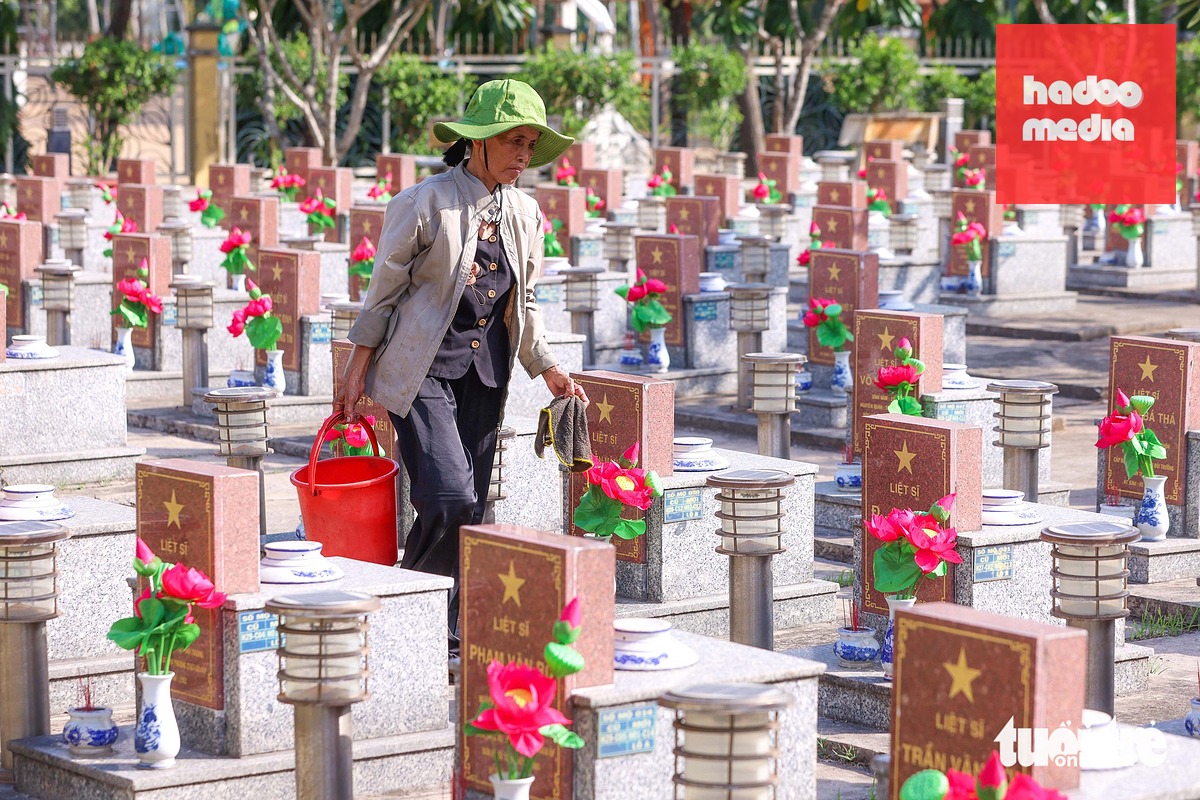 Gần như ngày nào cũng vậy, bà Nguyễn Thị Ngọc Hiệp đều dành phần lớn thời gian để chăm sóc nơi an nghỉ của các liệt sĩ tại Nghĩa trang liệt sĩ Hóc Môn (TP.HCM) - Ảnh: HOÀNG TRIỀU