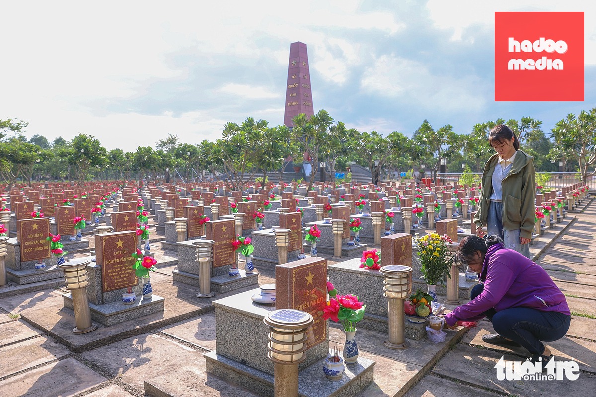 Mỗi khi có người đến viếng mộ, chỉ cần đọc tên liệt sĩ thì bà sẽ dẫn đến đúng chỗ mà không cần tra cứu sơ đồ - Ảnh: HOÀNG TRIỀU