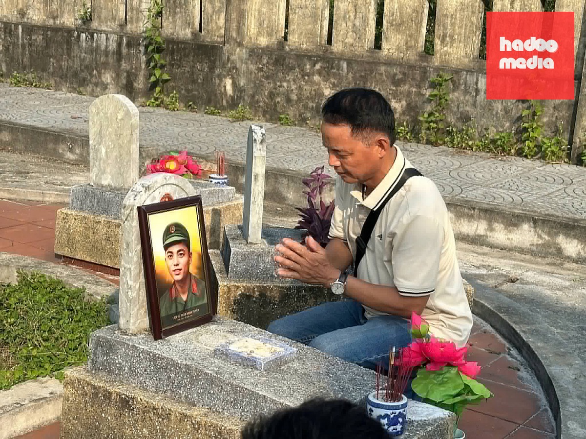 Ông Trần Văn Tâm (58 tuổi, Hưng Yên), em trai liệt sĩ Trần Minh Tuyến, bên di ảnh anh trai tại Nghĩa trang liệt sĩ Hải Lăng, Quảng Trị. Ảnh: Nhân vật cung cấp