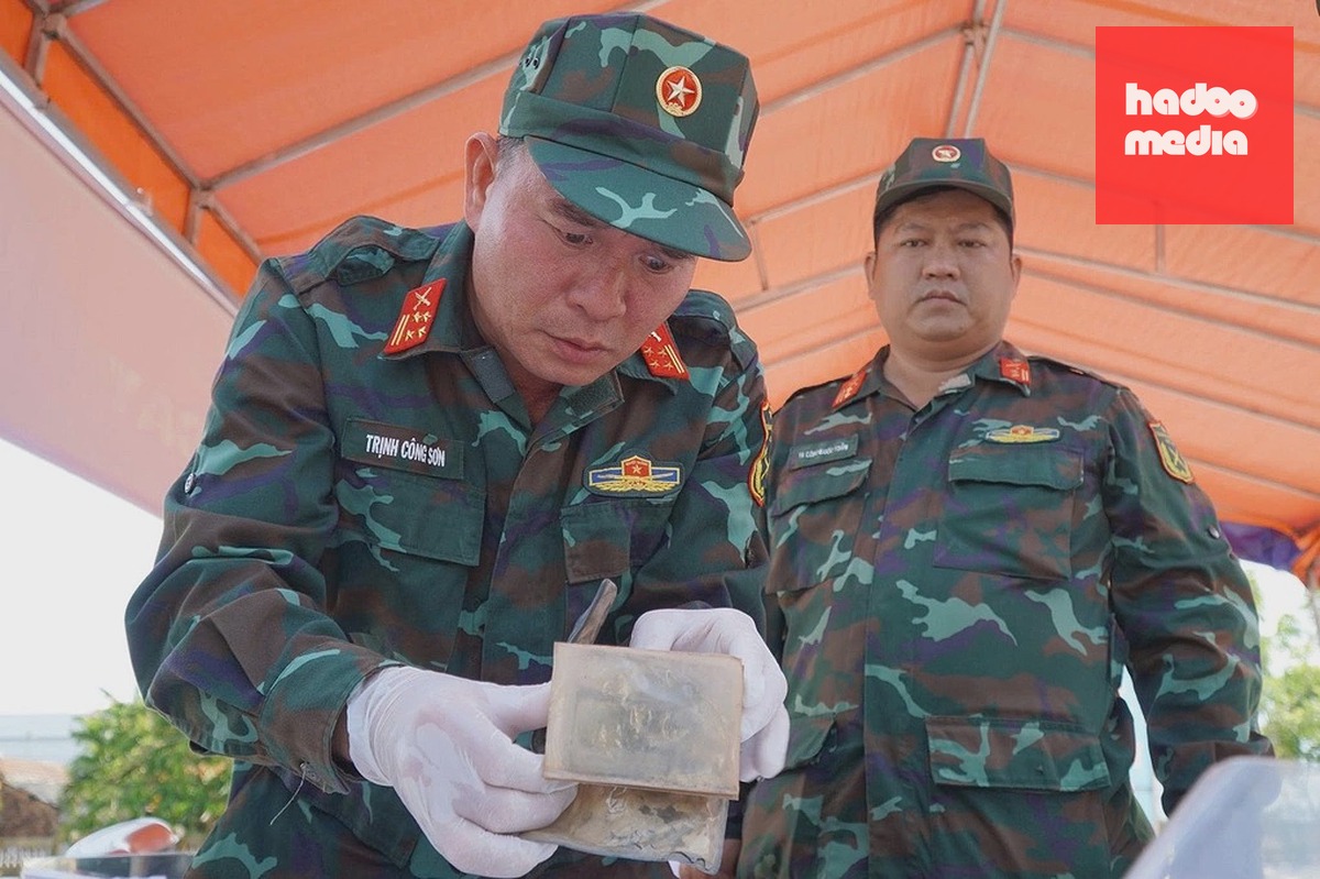 Đại tá Trịnh Công Sơn (cầm ví) cho biết đơn vị sẽ phục chế hai bức ảnh để đối chiếu hồ sơ, tìm thân nhân. Ảnh: Ngọc Linh