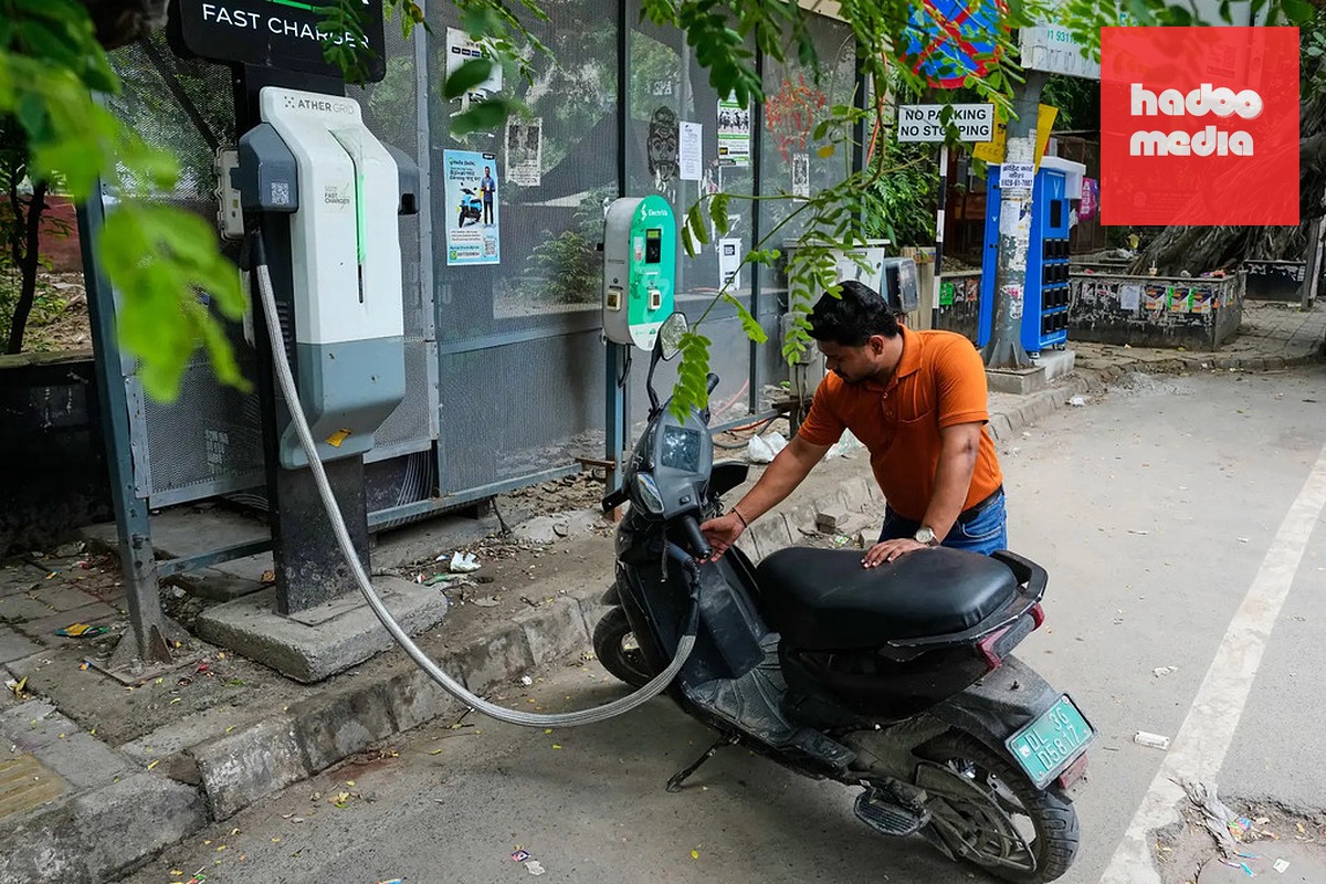 Một người đang sạc xe máy điện ở New Delhi, Ấn Độ, ngày 13/7. Ảnh: AP