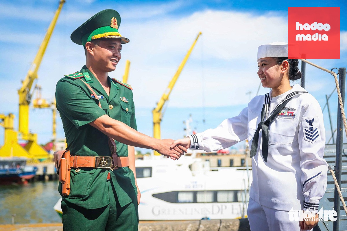 Y Vân (phải) - thủy thủ người Mỹ gốc Việt làm việc trên tàu sân bay USS George Washington, bắt tay một sĩ quan Biên phòng Việt Nam khi đến Đà Nẵng - Ảnh: NGUYỄN KHÁNH