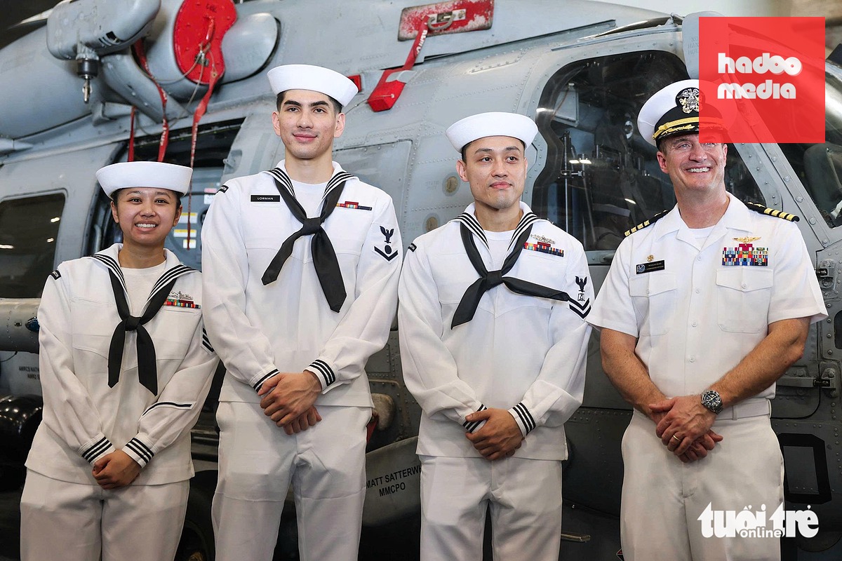 Lorman (thứ hai từ trái sang) và các thủy thủ gốc Việt tham gia đón khách tham quan tàu sân bay USS George Washington - Ảnh: NGUYỄN KHÁNH