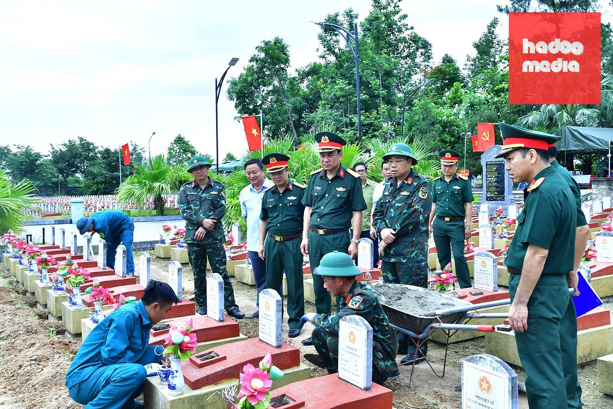 Các cán bộ, chiến sĩ lấy mẫu sinh phẩm giám định ADN ở Nghĩa trang liệt sĩ Đô Lương, Nghệ An - Ảnh: DOÃN HÒA