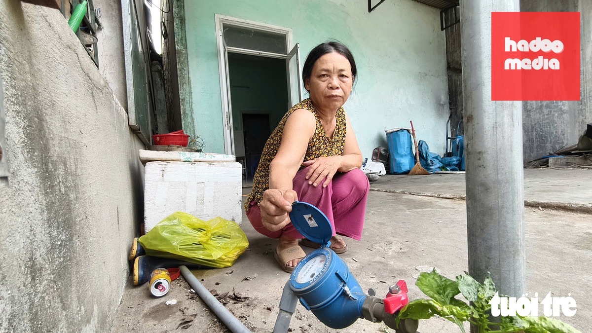 Bà Võ Thị Thanh Liên nộp gần 1,4 triệu đồng để lắp đồng hồ nước sạch - Ảnh: NGUYỄN YÊN