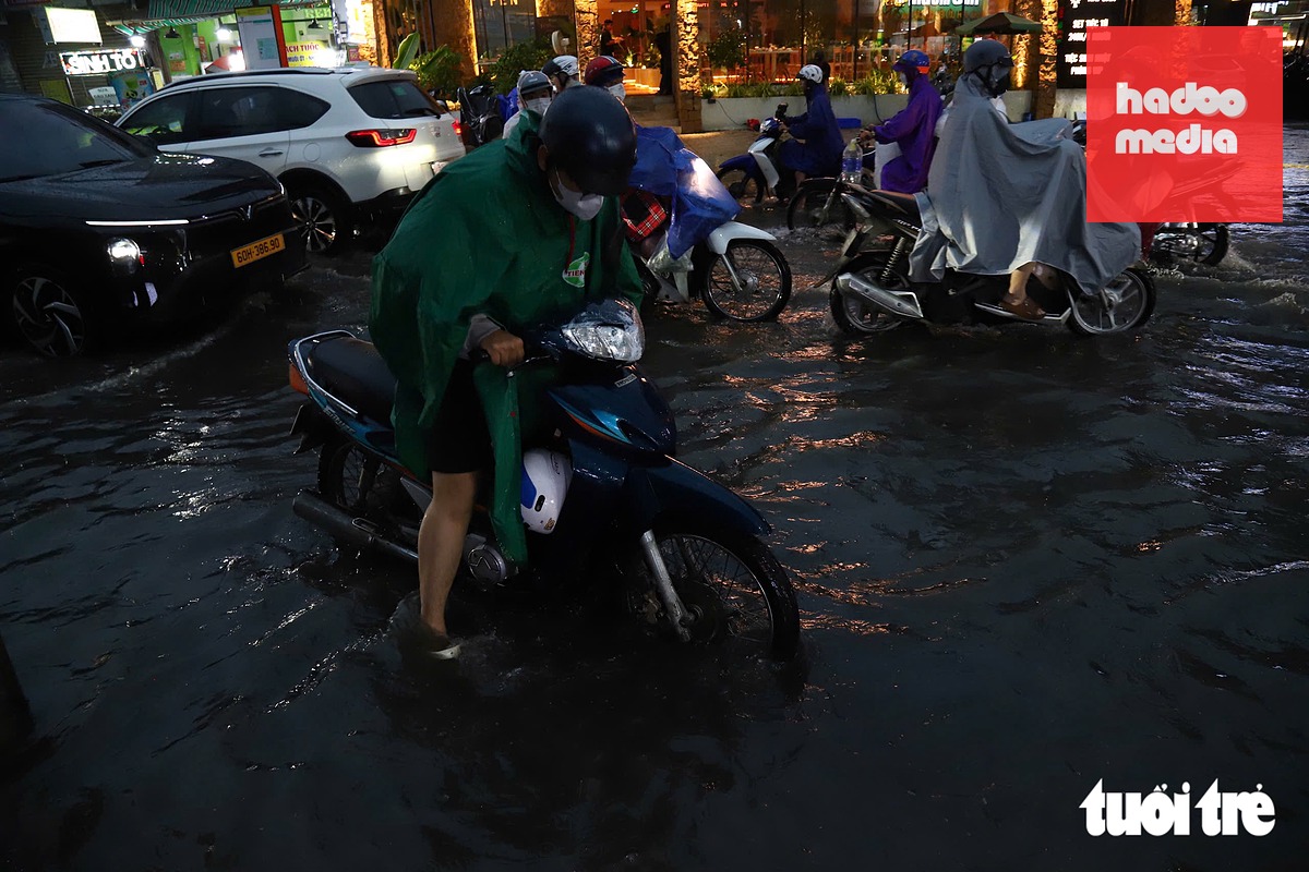 Tuy đường Phạm Văn Chiêu ngập không sâu nhưng cũng khiến việc di chuyển của người dân gặp khó khăn - Ảnh: NGỌC LÂN