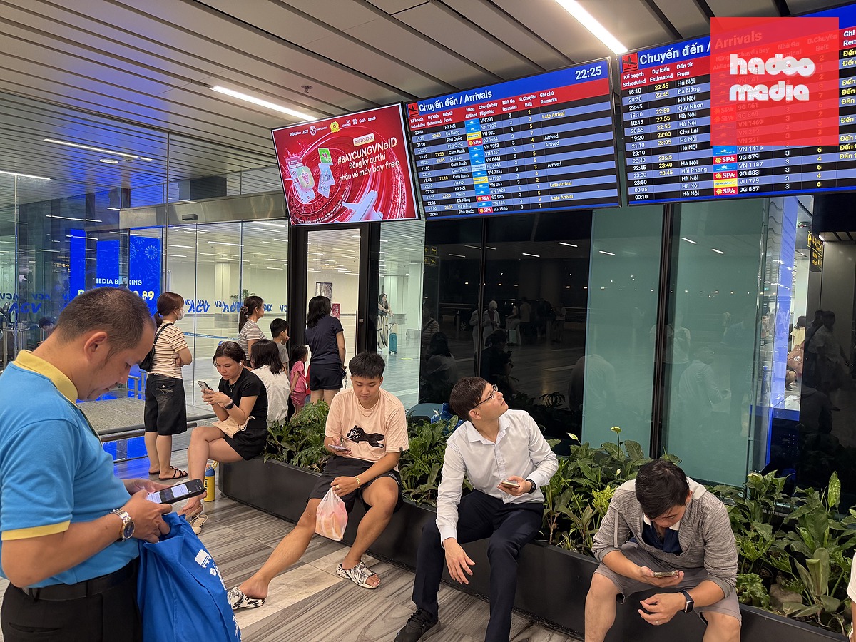 Đến 23h, nhiều người vẫn ngồi chờ tại ga đến, liên tục theo dõi thông tin chuyến bay để đón người thân do hàng loạt chuyến chậm dây chuyền sau sự cố drone xâm nhập trái phép - Ảnh: CÔNG TRUNG