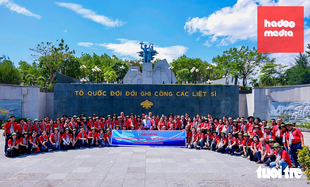 Đoàn chụp ảnh lưu niệm tại Nghĩa trang liệt sĩ quốc gia Đường 9 - Ảnh: QUANG ĐỊNH