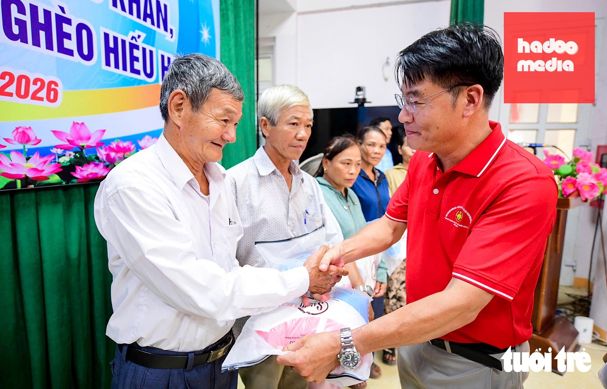 Nhà báo Đinh Đức Thọ - Phó tổng biên tập báo Tuổi Trẻ - trao quà cho hộ gia đình khó khăn xã Ái Tử - Ảnh: QUANG ĐỊNH