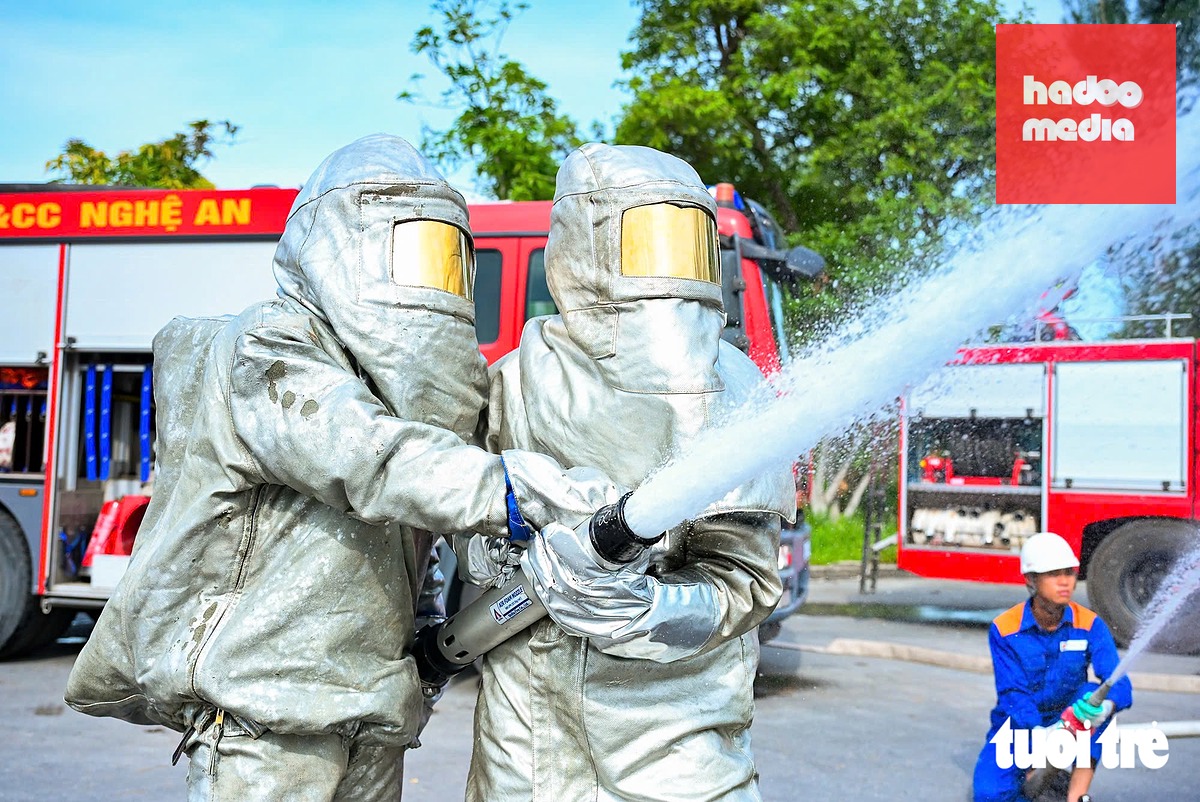 Cán bộ, chiến sĩ mặc bộ quần áo bảo hộ tráng nhôm phòng cháy chữa cháy, chịu nhiệt độ cao - Ảnh: DOÃN HÒA